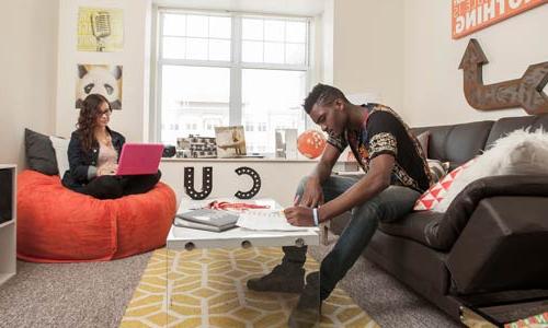 Photo of two students studying in dorm living room